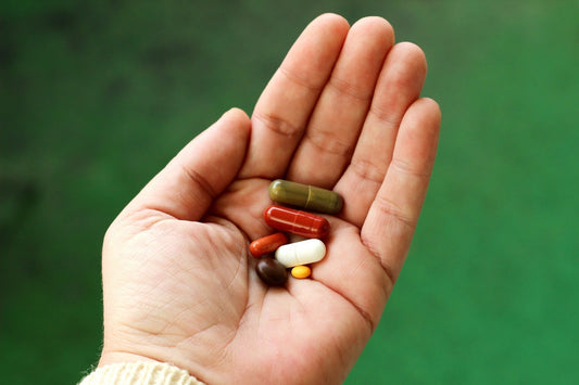 Hand met verschillende capsules en pillen voor mensen met moeite met pillen slikken